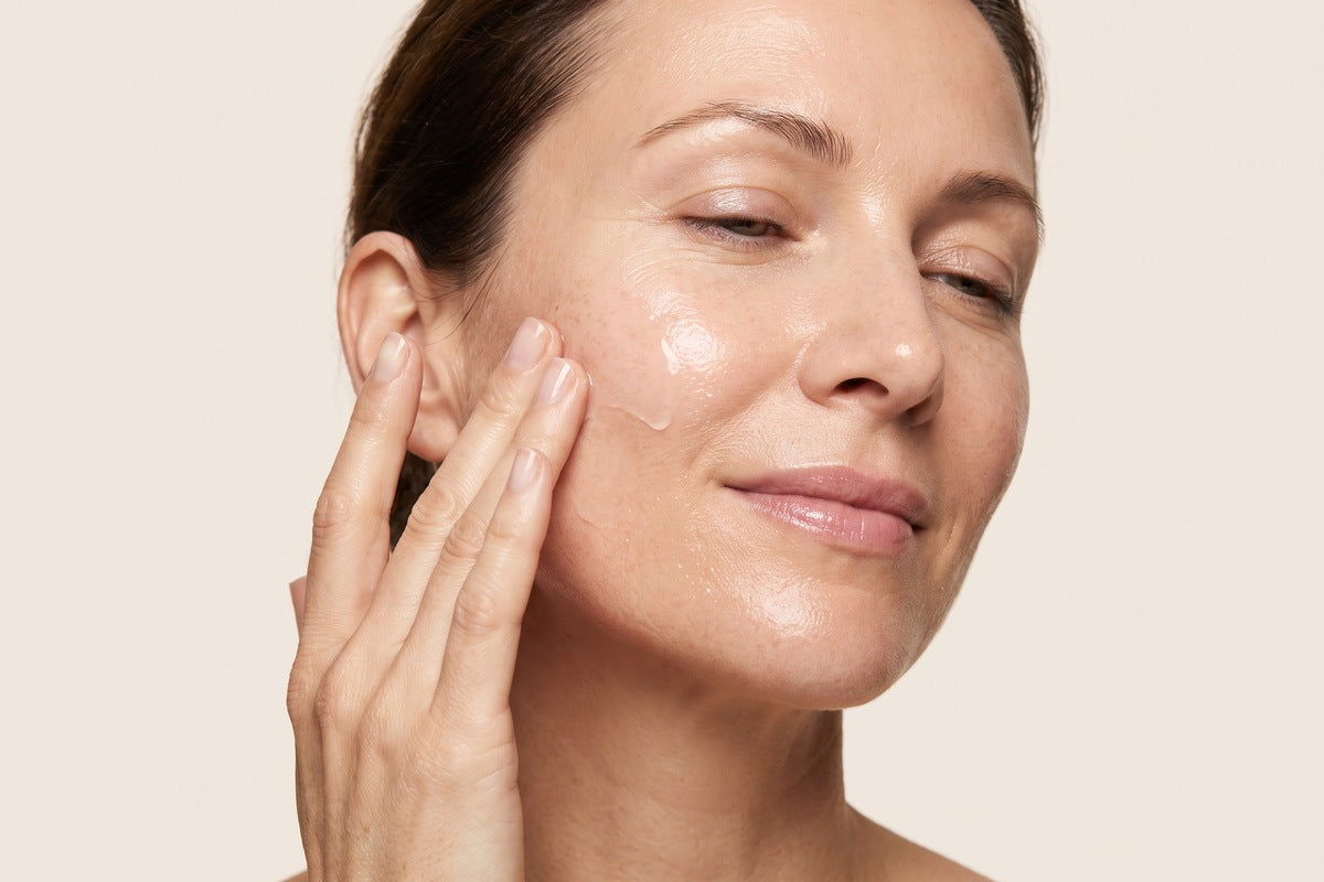 A woman pressing the serum into her cheek